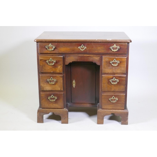 1020 - An C18th Georgian mahogany kneehole desk with moulded edge top over seven drawers and central recess... 