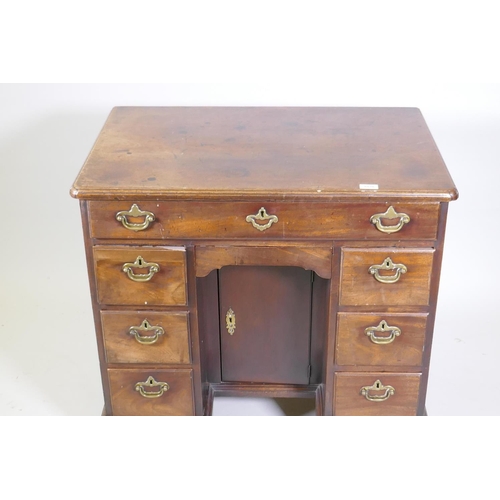 1020 - An C18th Georgian mahogany kneehole desk with moulded edge top over seven drawers and central recess... 