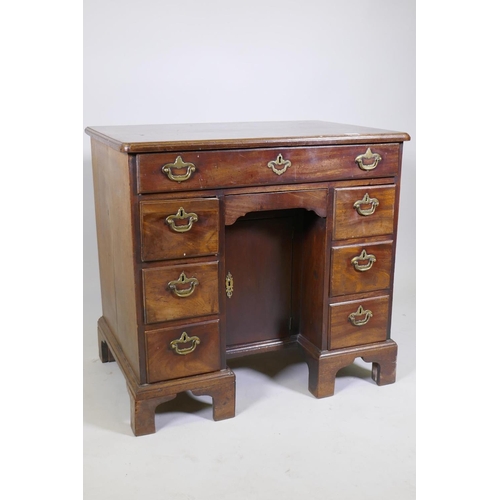 1020 - An C18th Georgian mahogany kneehole desk with moulded edge top over seven drawers and central recess... 