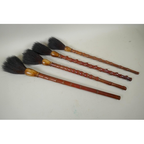 106 - Four vintage Chinese bamboo artist's brushes, 51cm long