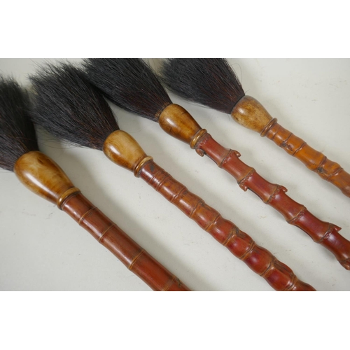 106 - Four vintage Chinese bamboo artist's brushes, 51cm long