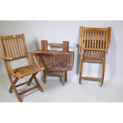 1097 - A pair of folding teak garden chairs and a folding table