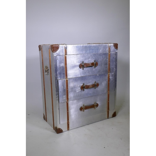 1118 - A metal veneered and leather mounted aviation style chest of three drawers, with carrying handles, 7... 