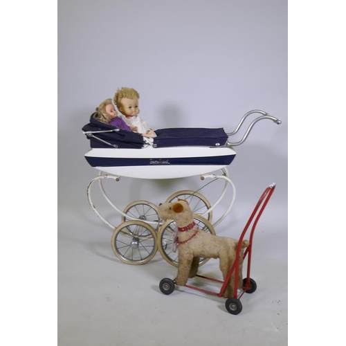 252 - A child's Tansad toy pram, a Pedigree Soft Toys push along dog walker and two celluloid dolls with r... 