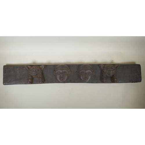 253 - An African carved wood tribal door mantle decorated with leopards and twin faces, 110 x 15cm