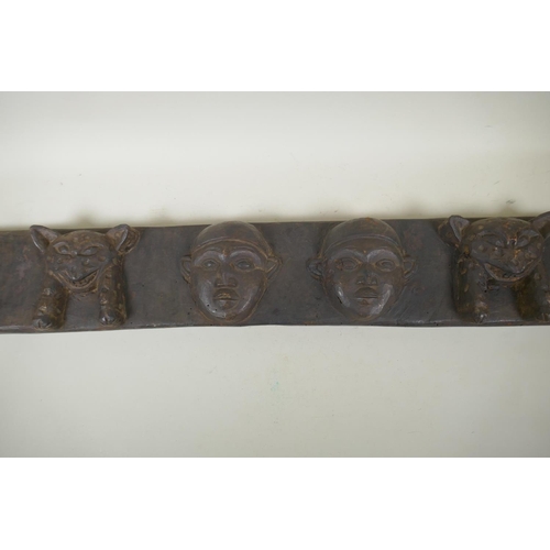 253 - An African carved wood tribal door mantle decorated with leopards and twin faces, 110 x 15cm