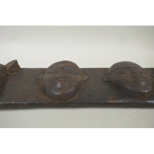 253 - An African carved wood tribal door mantle decorated with leopards and twin faces, 110 x 15cm