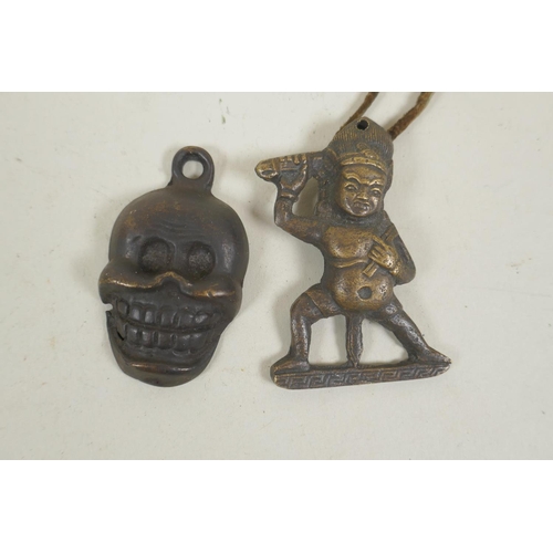 254 - A Tibetan bronze citipati death mask pendant, and a pendant in the form of a wrathful deity