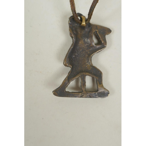 254 - A Tibetan bronze citipati death mask pendant, and a pendant in the form of a wrathful deity