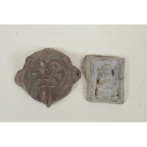 257 - A Tibetan lead(?) amulet of Buddha, and a bronze lion head mount filled with lead, 8 x 7cm