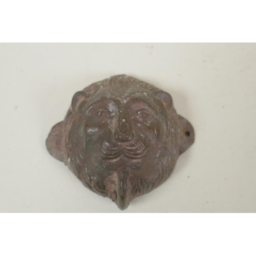 257 - A Tibetan lead(?) amulet of Buddha, and a bronze lion head mount filled with lead, 8 x 7cm