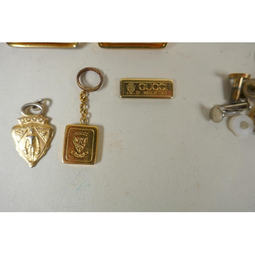 264 - A quantity of Gucci gilt metal and brass fittings, belt hooks, clasps, studs, locks, etc and a catal... 