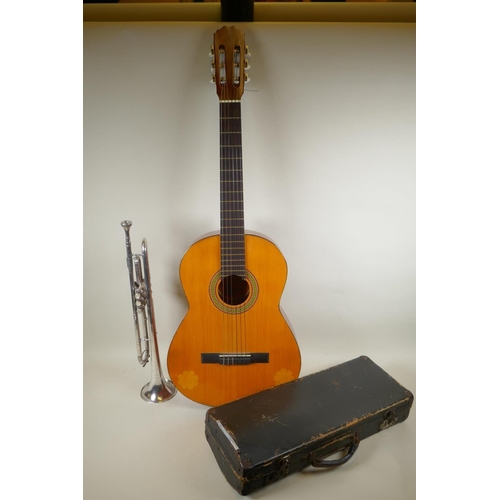 275 - A Spanish classical guitar by BM Espana, 101cm long, and a silver plated trumpet retailed by the Kin... 