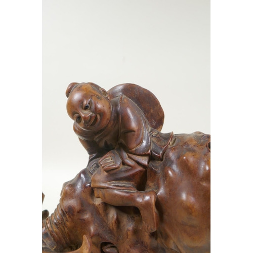 32 - An antique oriental carved root wood figure of a child riding a buffalo, 25cm high