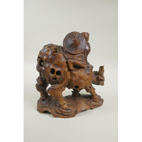 32 - An antique oriental carved root wood figure of a child riding a buffalo, 25cm high