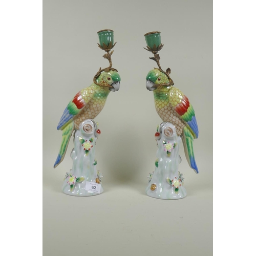 62 - Pair of porcelain and brass mounted candlesticks in the form of parrots, 36cm high