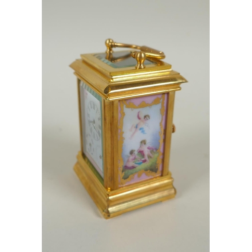 635 - A miniature gilt brass carriage clock with Sevres style paste panels, the dial with day and date sub... 