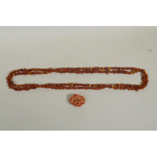 675 - A long string of natural amber, 46g, 168cm long, and a vintage coral brooch