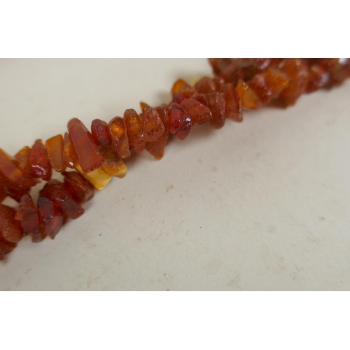 675 - A long string of natural amber, 46g, 168cm long, and a vintage coral brooch