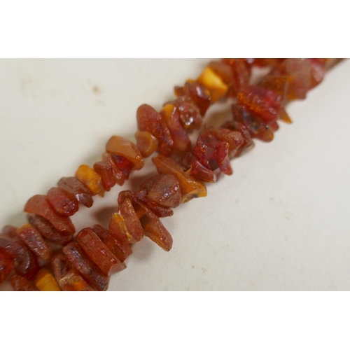 675 - A long string of natural amber, 46g, 168cm long, and a vintage coral brooch