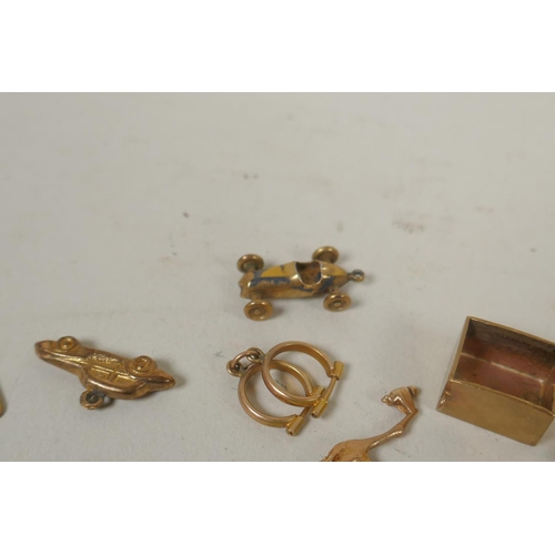 688 - A collection of 9ct gold charms, 15g, and a silver gilt charm in the form of a vintage racing car