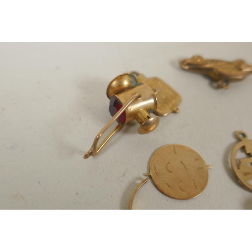 688 - A collection of 9ct gold charms, 15g, and a silver gilt charm in the form of a vintage racing car