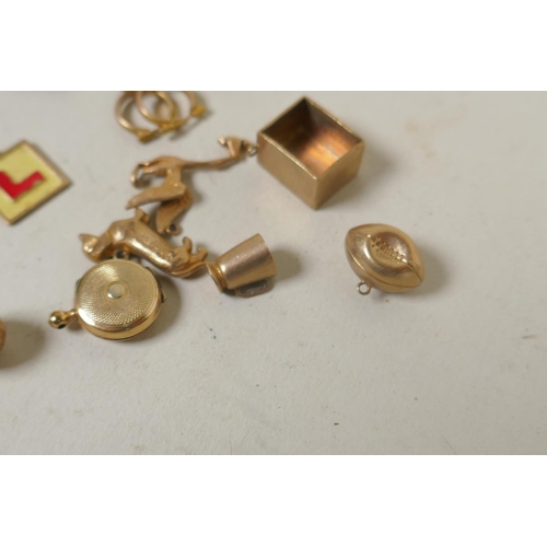 688 - A collection of 9ct gold charms, 15g, and a silver gilt charm in the form of a vintage racing car