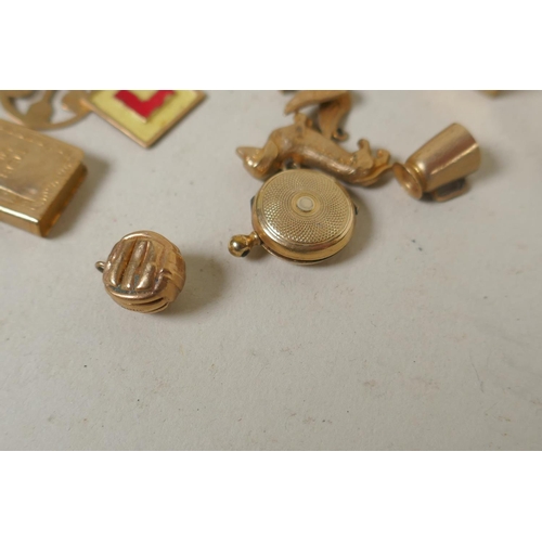 688 - A collection of 9ct gold charms, 15g, and a silver gilt charm in the form of a vintage racing car