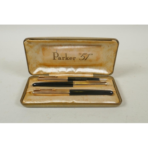 75 - A vintage Parker 51 three pen case containing a pair of fountain pens with rolled gold caps and matc... 