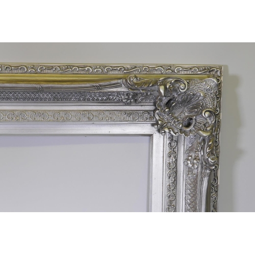 904 - A large silver coloured mirror/picture frame with composition moulded decoration, 153 x 223cm, rebat... 