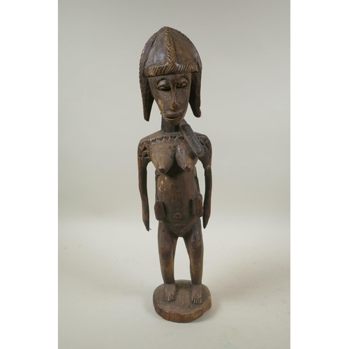 93 - An African carved hardwood figure of a mother and child, 47cm high