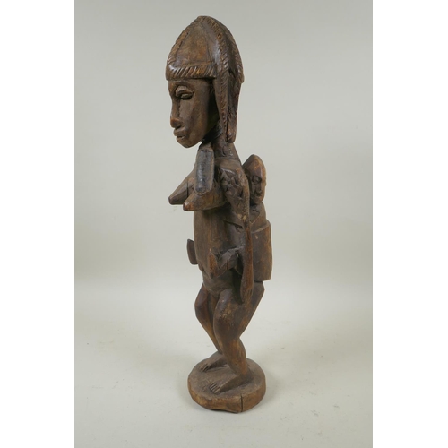 93 - An African carved hardwood figure of a mother and child, 47cm high