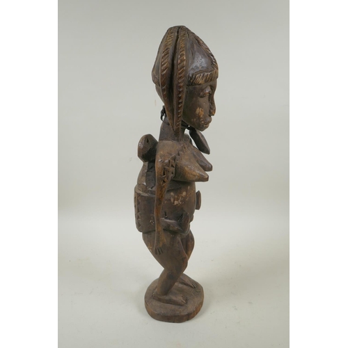 93 - An African carved hardwood figure of a mother and child, 47cm high