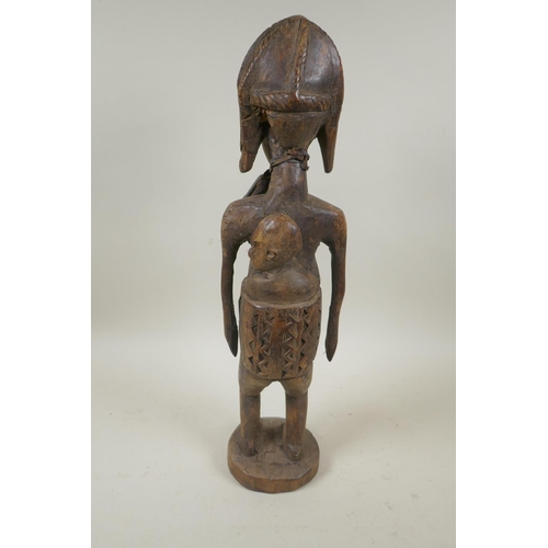 93 - An African carved hardwood figure of a mother and child, 47cm high