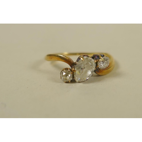 694 - An antique unmarked gold ring set with an old cut pear shaped diamond, approx 0.75ct, flanked by old... 