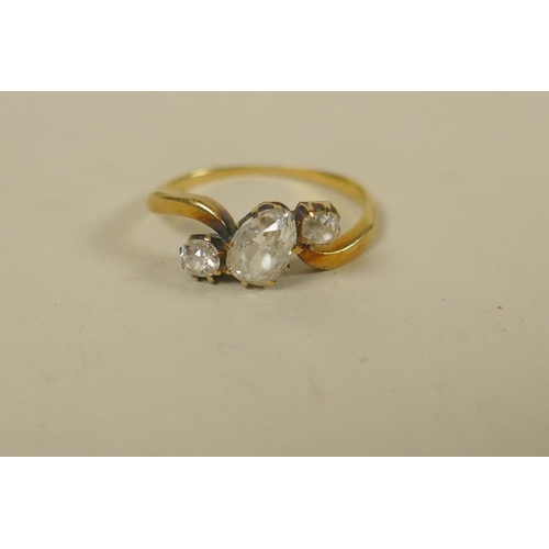 694 - An antique unmarked gold ring set with an old cut pear shaped diamond, approx 0.75ct, flanked by old... 