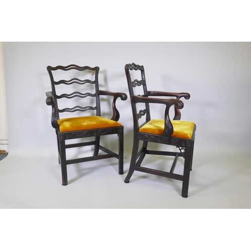 1005 - A pair of Chippendale style mahogany elbow chairs with pierced ladder backs and carved arms and rail... 