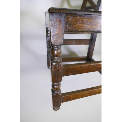 1031 - A set of eight William and Mary style panel backed oak chairs, with solid seats, raised on turned su... 