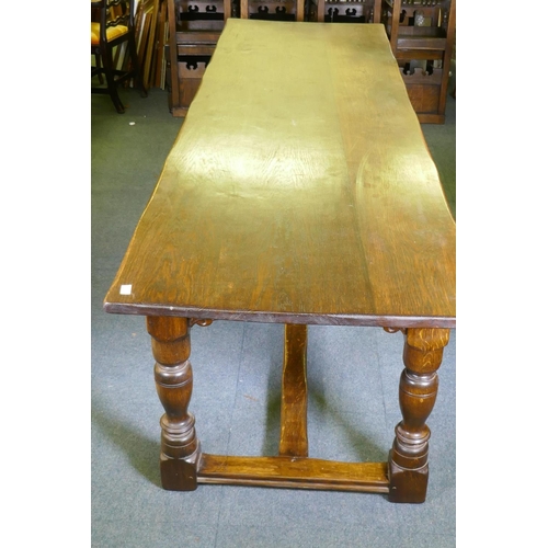 1032 - A William and Mary style oak refectory table, with planked top and carved frieze, raised on baluster... 