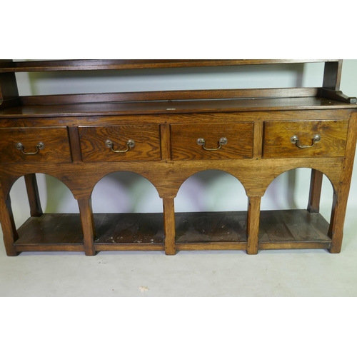 1033 - A Georgian style oak pot board dresser, with open delft rack over four drawers, raised on square cha... 