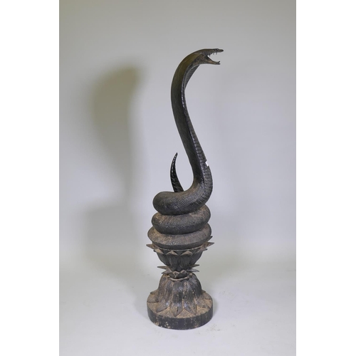 17 - A carved wood figure of a Cobra coiled upon a lotus dias, AF losses, 123cm high