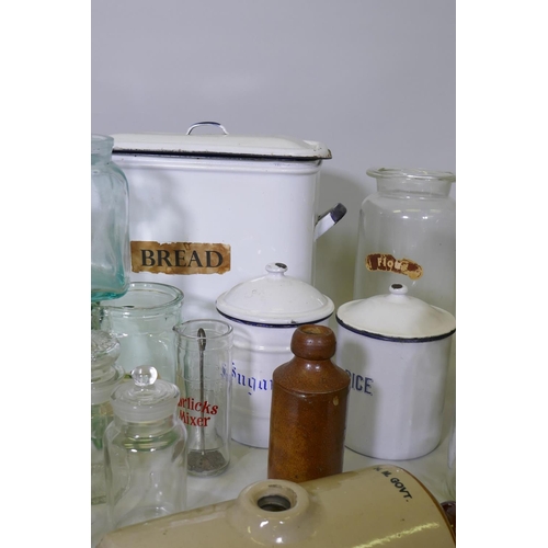 26 - A quantity of vintage kitchenalia, enamel storage jars, a bread bin, glass jars, stoneware demi john... 