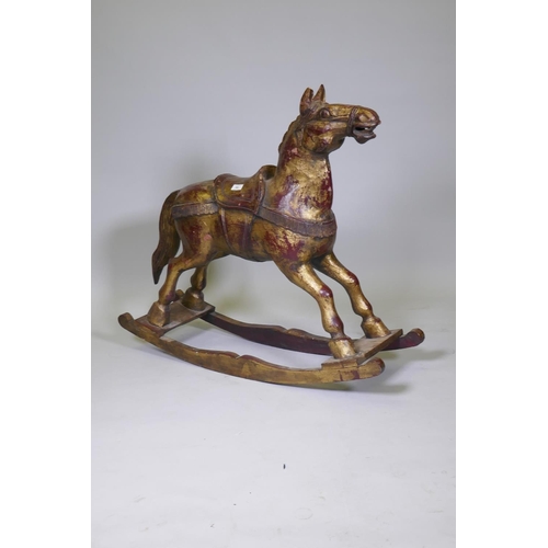 64 - A carved wood rocking horse with painted and parcel gilt decoration, 88cm high