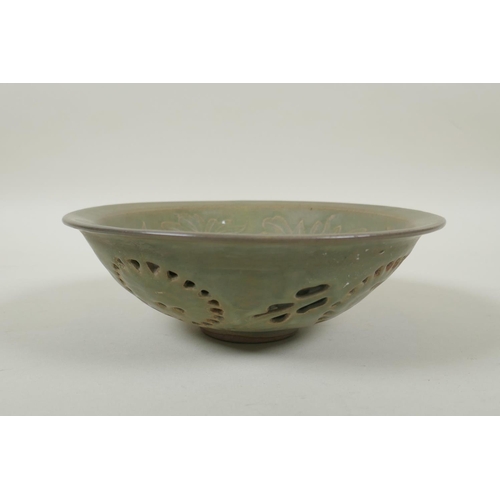 75 - A Chinese song style olive glazed porcelain double walled bowl with reticulated floral decoration to... 