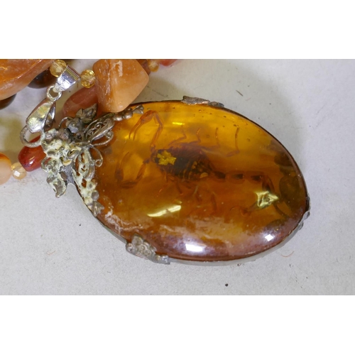 96 - A quantity of British and world coins, an agate necklace with amber style pendant inset with a scorp... 