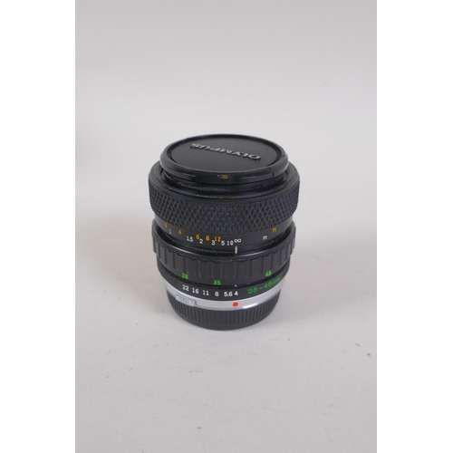 29 - An Olympus OM-4 Ti 35mm SLR camera, with two Olympus OM-system Zuiko lenses - OM 180mm F2.8 and OM 2... 