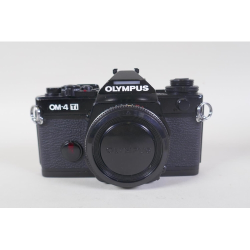 29 - An Olympus OM-4 Ti 35mm SLR camera, with two Olympus OM-system Zuiko lenses - OM 180mm F2.8 and OM 2... 