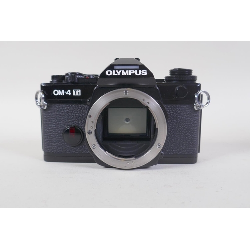 29 - An Olympus OM-4 Ti 35mm SLR camera, with two Olympus OM-system Zuiko lenses - OM 180mm F2.8 and OM 2... 