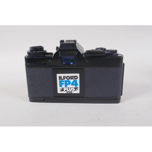 29 - An Olympus OM-4 Ti 35mm SLR camera, with two Olympus OM-system Zuiko lenses - OM 180mm F2.8 and OM 2... 