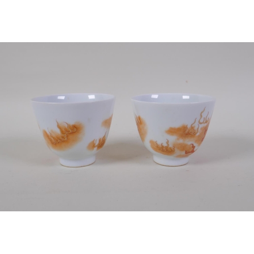 35 - A pair of early C20th Chinese red and white porcelain tea bowls with fo dog decoration highlighted w... 